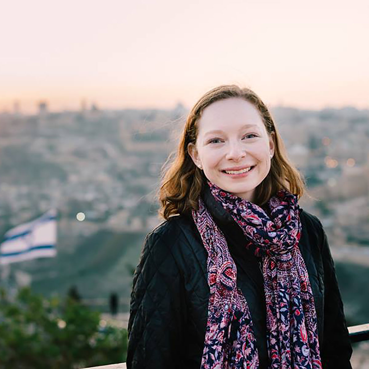 A Hillel engagement intern poses for a portrait photograph with the Israeli flag in the background