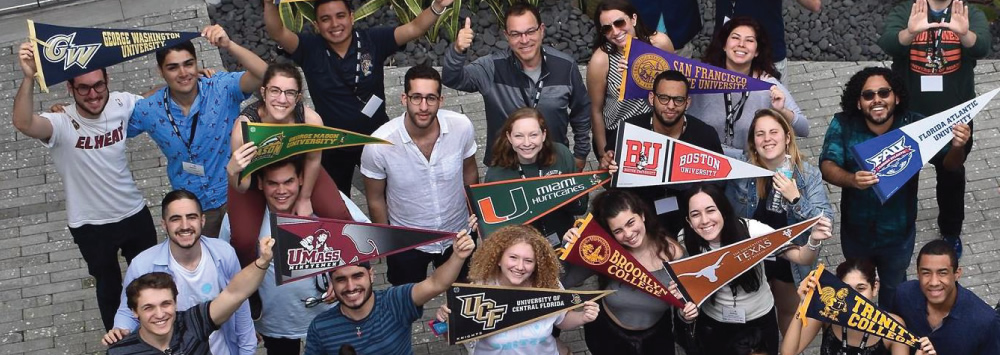 Group of college students with school pennants.